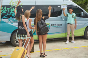 Three female friends waving at their airport transfer van driver on the way to a resort in Coron